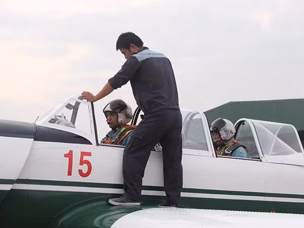 Kỹ thuật viên giúp phi công chuẩn bị buồng lái.