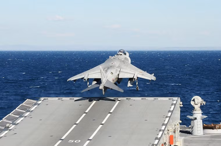 Tuy có thể cất hạ cánh thẳng đứng, nhưng khi mang tải trọng đầy đủ thì người ta thường cho máy bay V/STOL chạy đà trên đường băng ngắn với boong phóng kiểu nhảy cầu dốc 12 độ. Ảnh: Một chiếc AV-8S cất cánh từ cầu dốc 12 độ trên tàu sân bay hạng nhẹ.