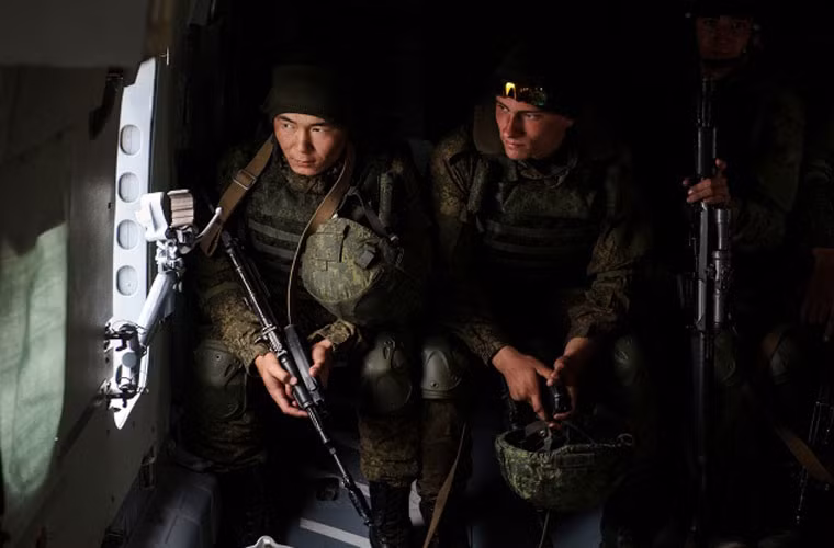 Hai binh sĩ ngồi trên trực thăng Mi-8 đưa tới điểm đổ bộ.