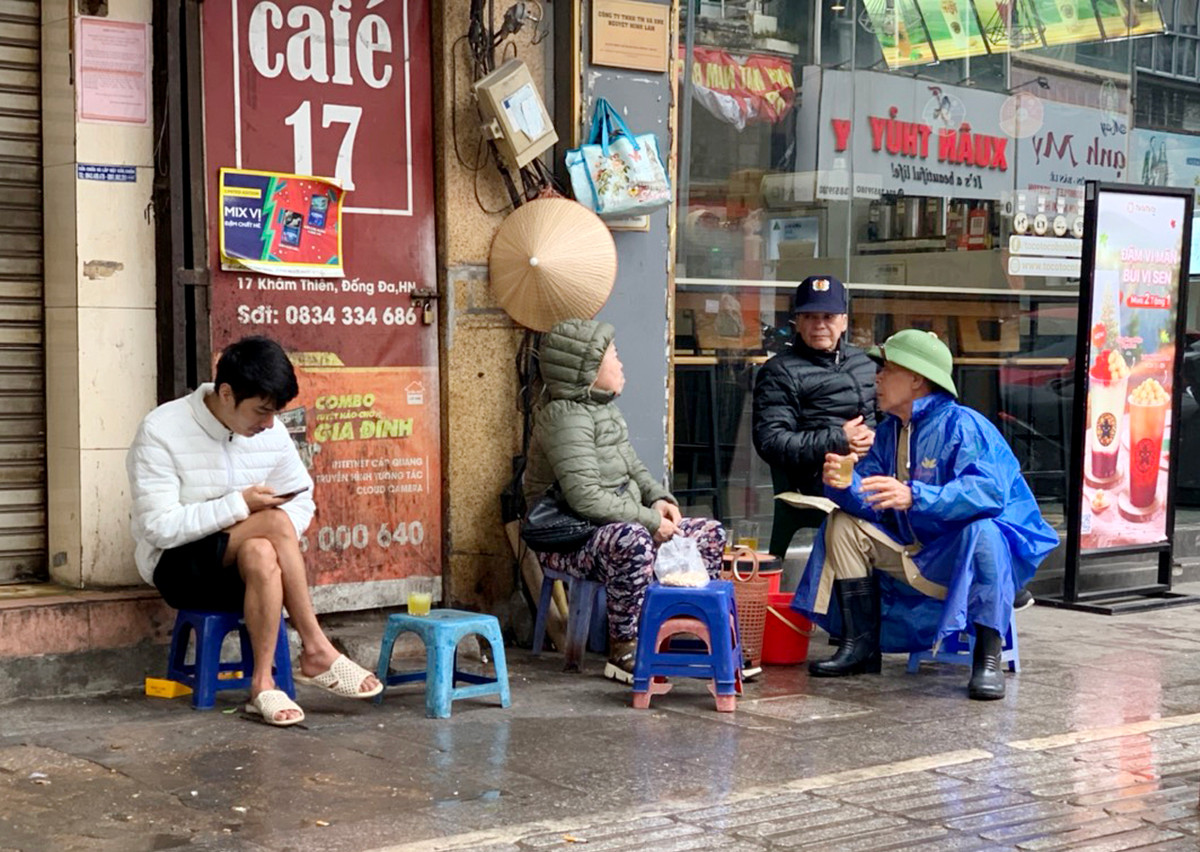 Bác tự quản già tranh thủ nhấp ngụm trà nóng cho ấm người trong lúc làm nhiệm vụ.