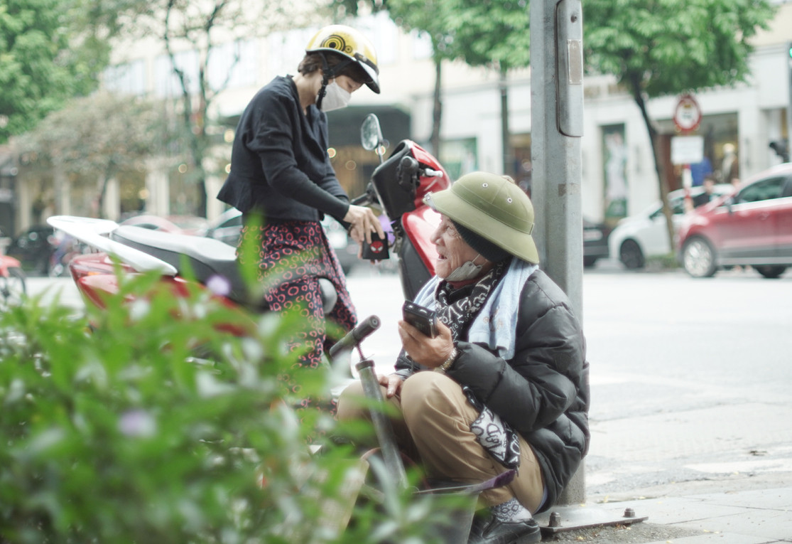 Cụ già ngồi co ro tại ngã tư phố Bà Triệu - Hai Bà Trưng chờ người bơm xe.