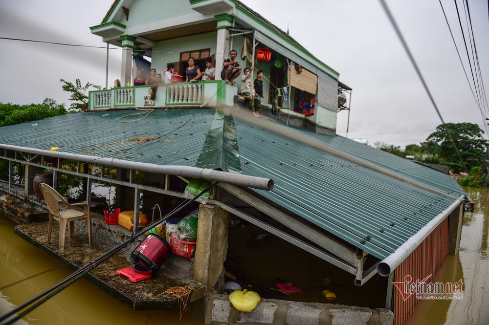 Người dân leo lên nhà cao tầng, chờ lực lượng cứu hộ tới đưa đi tránh lũ.