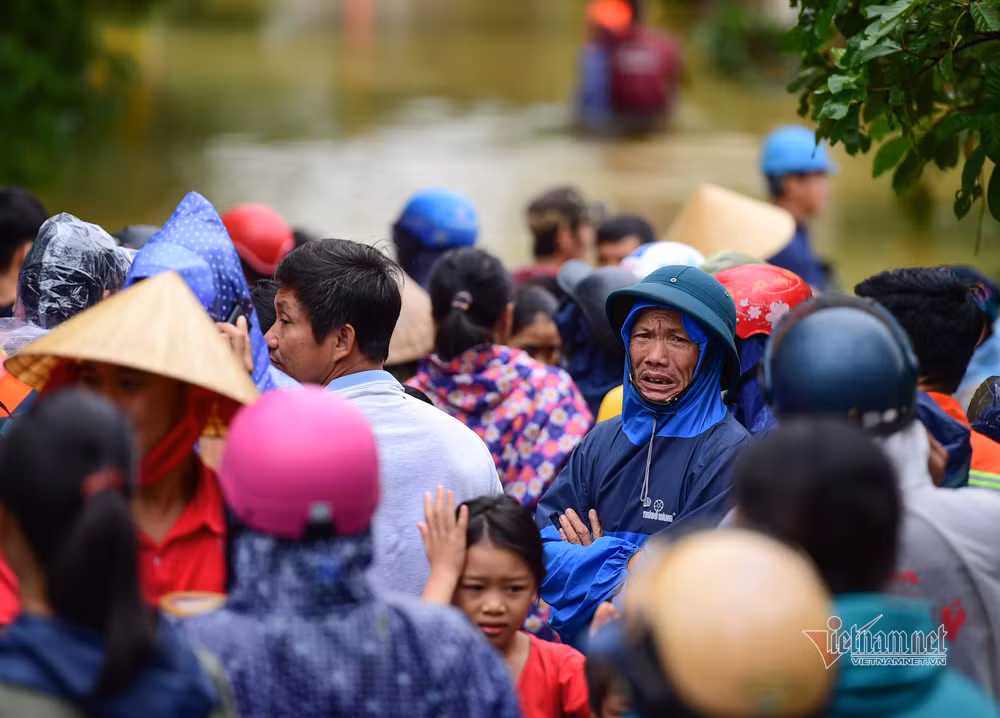 Người dân trên bờ trong ngóng người thân còn kẹt giữa vùng nước ngập.