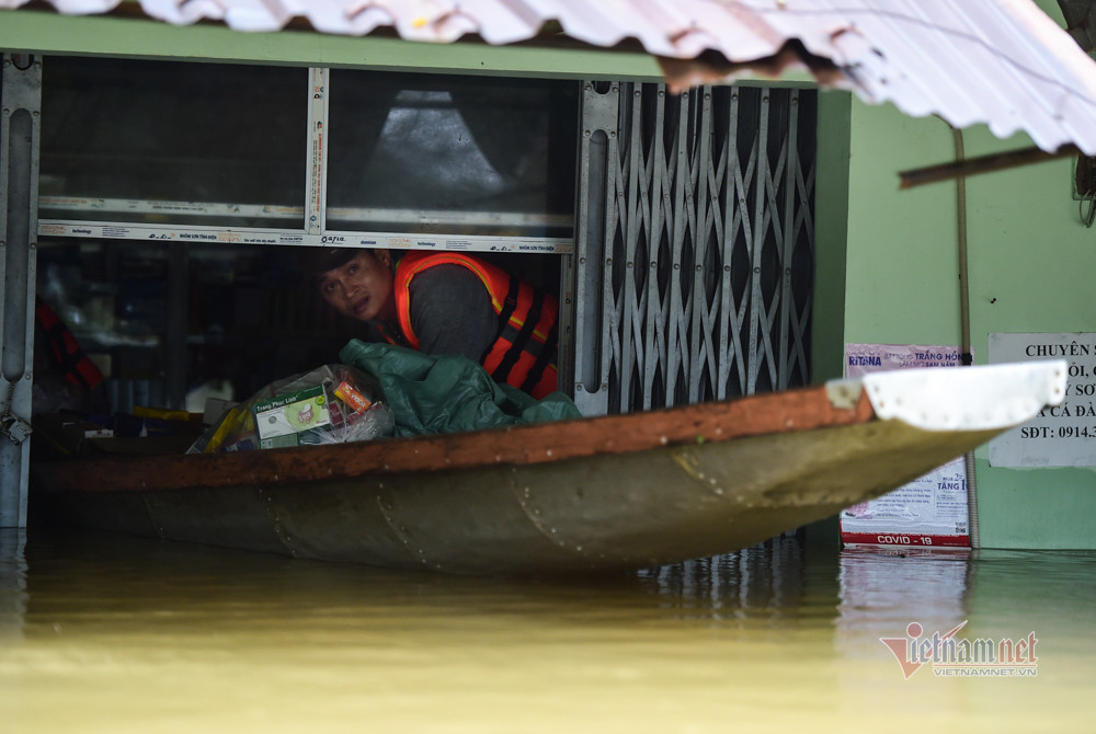 Người dân dùng thuyền để vận chuyển đồ đạc tránh lũ. 