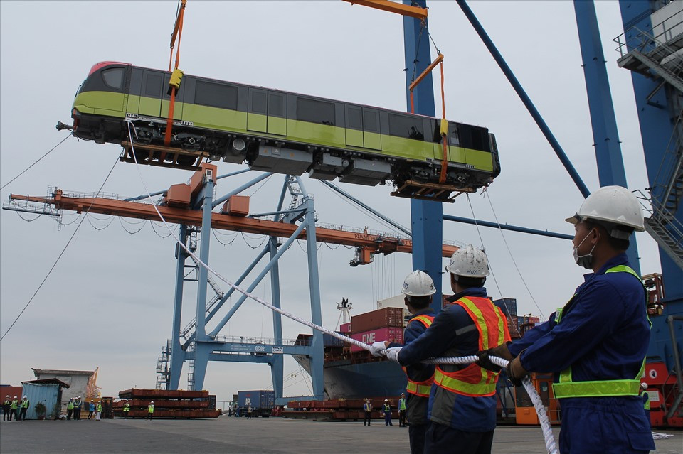 Sau khi cập cảng Hải Phòng, đoàn tàu sẽ được vận chuyển bằng xe siêu trường siêu trọng tới khu Depot Nhổn (Hà Nội), thực hiện lắp đặt lên ray để vận hành thử nghiệm trước khi vận hành chính thức. (Cán bộ, kỹ thuật viên và công nhân tập trung cao độ, bảo đảm xếp dỡ toa tàu an toàn tuyệt đối. Ảnh MD)