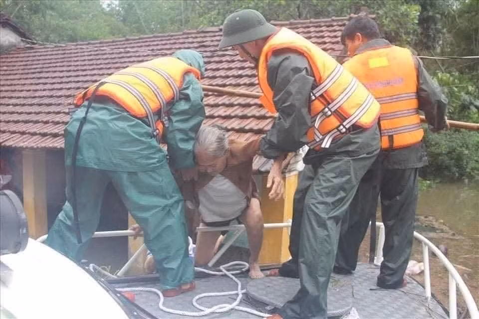 Người già được lực lượng chức năng giải cứu khỏi vùng bị cô lập do lũ. 