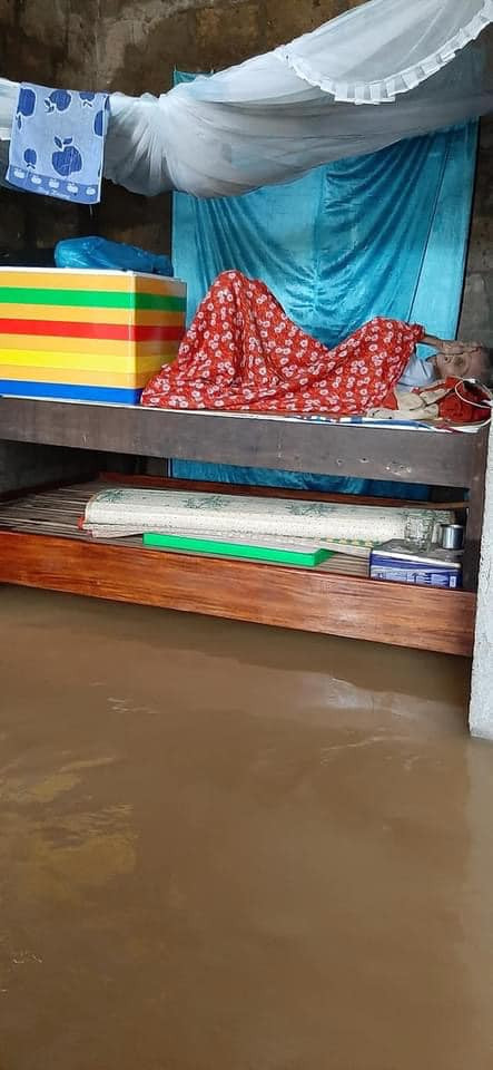 Cụ bà nằm trên giường kê cao, bên dưới là nước lũ, chờ đợi lực lượng cứu hộ đến để đưa đến khu vực an toàn khiến nhiều người không khỏi xót xa. 