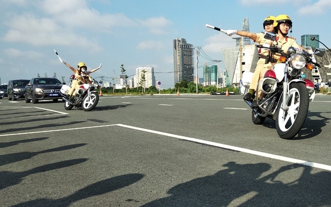 Các nữ CSGT lập đội hình, sa bàn dẫn đoàn trên đường phố. (Ảnh: Công an nhân dân).