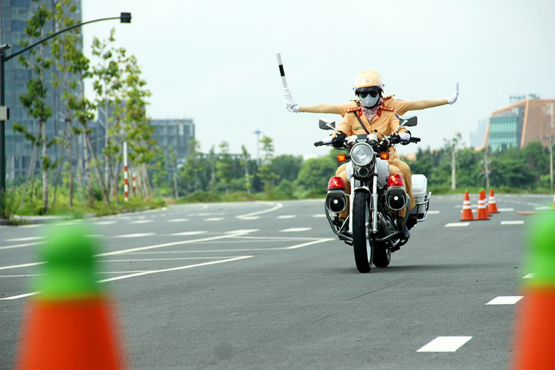 Các nữ CSGT ngồi sau vững vàng, tay cầm gậy điều lệnh đưa lên đưa xuống nhịp nhàng. (Ảnh: Pháp luật TP HCM).