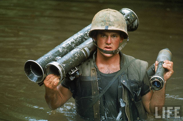 Lính thủy đánh bộ Mỹ mang theo rocket khi di chuyển qua một con sông ở Việt Nam.