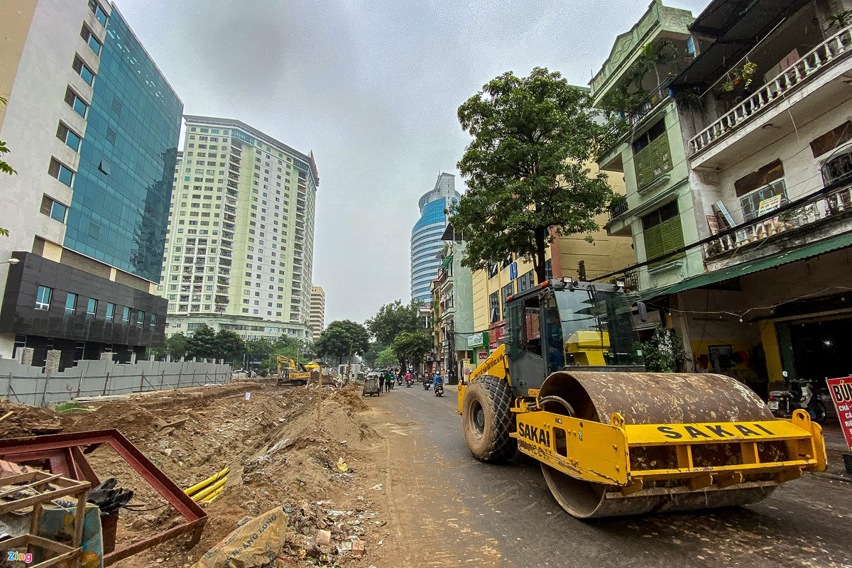 Đoạn đường cạnh ngõ 14 phố Pháo Đài Láng đã hoàn thành lát đá vỉa hè, trồng cây xanh lòng đường được trải nhựa, nhưng nhiều nhà dân vẫn chưa được giải phóng mặt bằng.