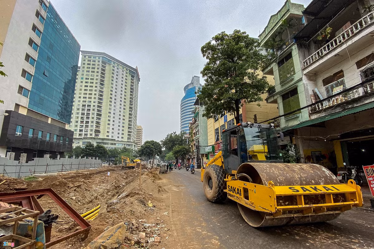 Đoạn đường cạnh ngõ 14 phố Pháo Đài Láng đã hoàn thành lát đá vỉa hè, trồng cây xanh lòng đường được trải nhựa, nhưng nhiều nhà dân vẫn chưa được giải phóng mặt bằng.