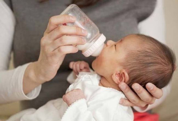 Để giữ nhiệt cho sữa, bố mẹ có thể dùng khăn sạch quấn quanh bình, giúp sữa không bị nguội quá nhanh. Sữa ấm nóng sẽ giúp bé quen miệng uống hết không gây lãng phí. Ảnh: 163.com