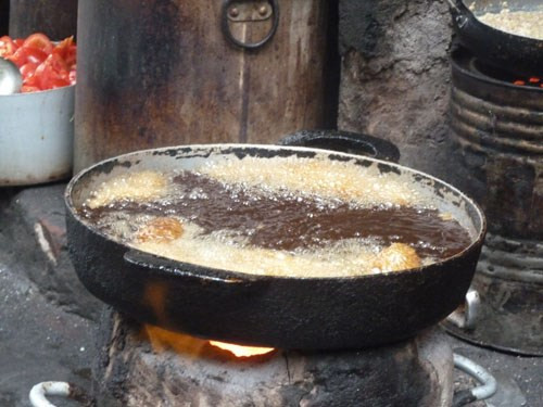 Dầu mỡ không rõ nguồn gốc, việc chiên đi chiên lại cá trong dầu cháy đen ngòm thế này sẽ ảnh hưởng không tốt đến sức khỏe của người dùng. Ảnh: DNVN.