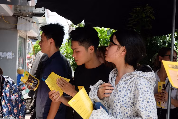 Nhiều khách nữ mặc áo chống nắng xếp hàng.