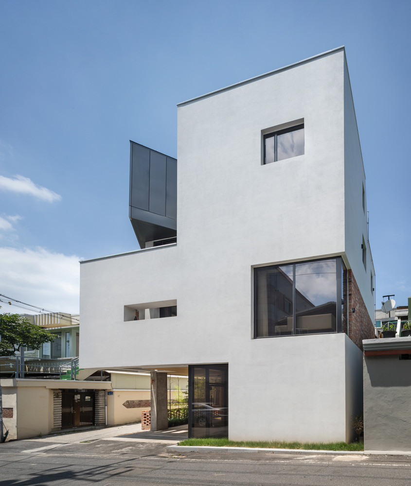 Nhìn từ bên ngoài, ngôi nhà được sơn màu trắng với thiết kế hình khối hiện đại.