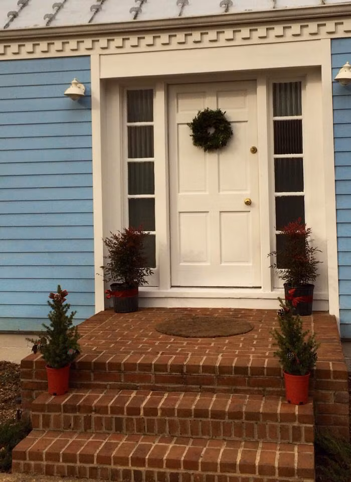 Cửa vào mang phong cách châu Âu pha trộn hiện đại với màu sơn trắng và cổ điển là bậc thềm gạch thô.