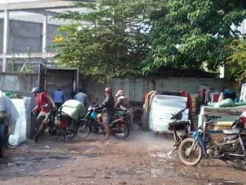 Hàng loạt đá cây được sản xuất ngay ngoài sân bẩn, dưới nền đất đỏ nhầy nhụa, xe qua lại bắn tung tóe. Ảnh; Người đưa tin.