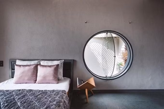 Cửa sổ hình tròn trong phòng ngủ tạo sự bình yên, thư thái giúp bạn dễ dàng đắm chìm vào giấc ngủ. Ảnh: Alonhadat.