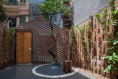 Nằm trên một con hẻm nhỏ ở đường Hào Nam, Đống Đa (Hà Nội), ngôi nhà này nổi bật hơn hẳn những ngôi nhà xung quanh bởi cánh cổng bằng gỗ và gạch mộc rất độc đáo. (Ảnh Baodatviet)