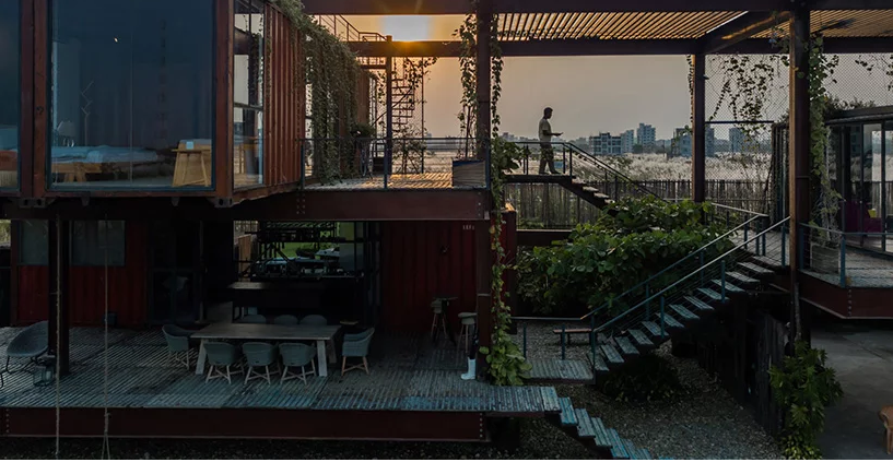 Ngôi nhà container có 3 tầng với nhiều ban công và ô cửa lớn.