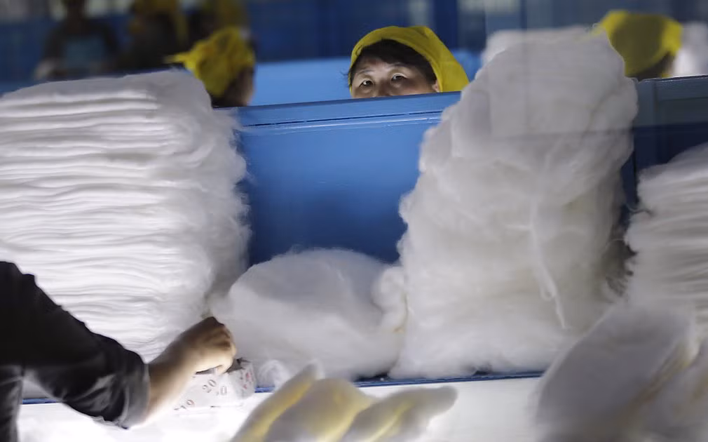 Một nữ công nhân tò mò nhìn khi thấy ống kính máy ảnh.