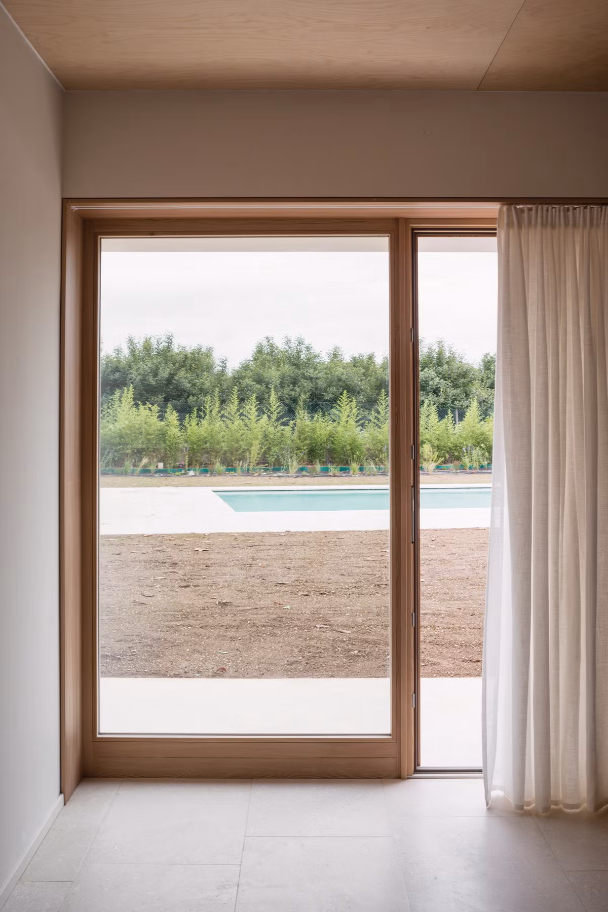 Phòng ngủ có view tuyệt đẹp nhìn ra bể bơi. Ảnh: Dezeen.