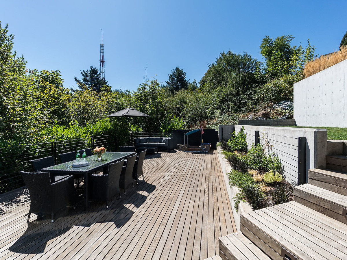 Một khu vực thư giãn ngoài trời rộng rãi phía dưới với sàn được ốp gỗ.