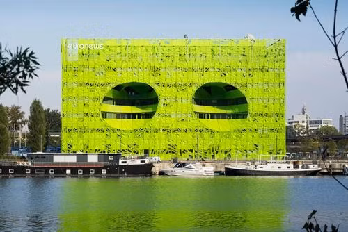Tòa nhà của tòa soạn báo Euronew ở Lyon, Pháp. Nằm dọc theo bờ sông Saône ở Lyon, là một phần của quy hoạch tổng thể rộng lớn nhằm đổi mới diện mạo của thành phố. Thiết kế mang đến ánh sáng tự nhiên và không khí vào bên trong và cũng cung cấp cảnh quan tuyệt đẹp của đường thủy liền kề.