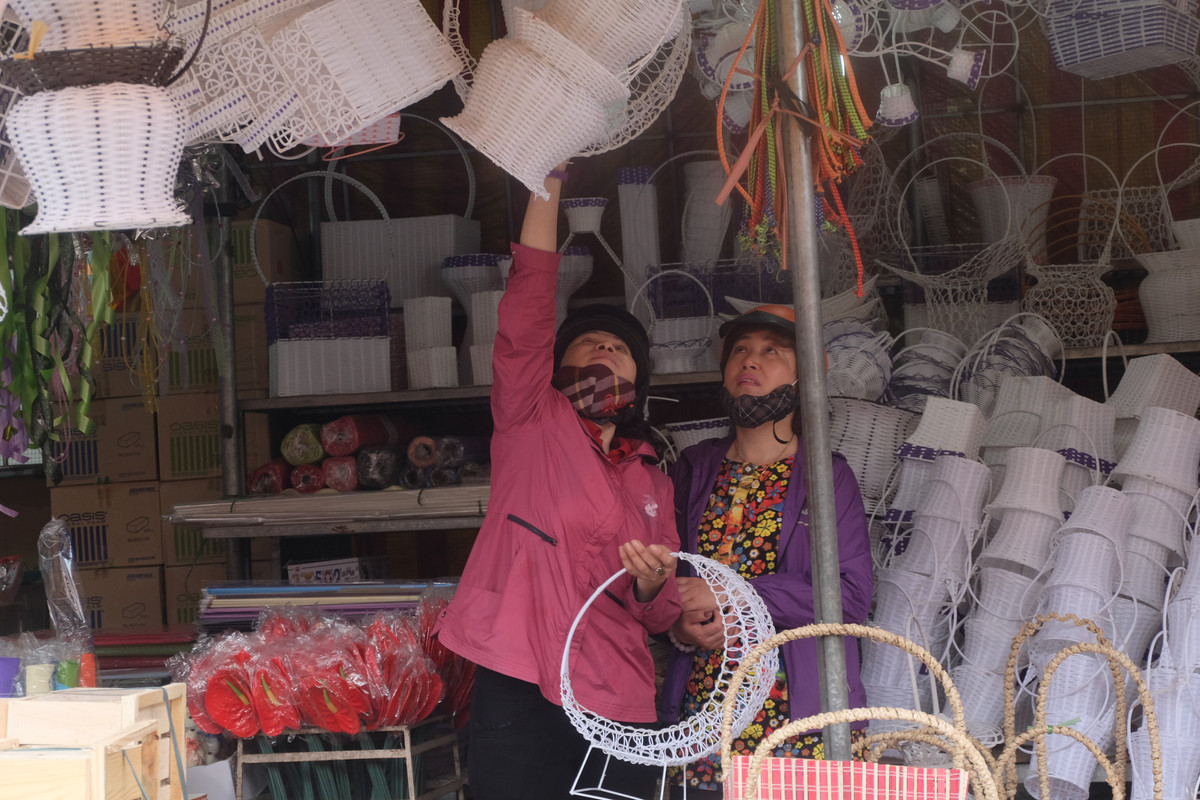 Ngoài gian hàng hoa, cửa hàng bán lẵng hoa, bình hoa cũng rất đông khách. Trung bình, lẵng hoa làm bằng cói hoặc sắt có giá 50.000 - 150.000 đồng/chiếc (tùy theo kích thước).