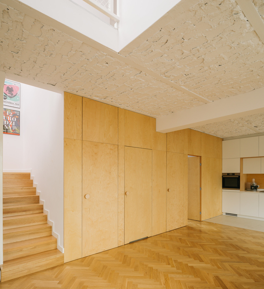 Do trần nhà tương đối thấp nên các kiến trúc sư đã sử dụng chất liệu gỗ sáng màu cho sàn nhà, cầu thang và nội thất để không gian không bị tù túng, ngột ngạt. Ảnh: Maciej Jeżyk / ONI Studio.