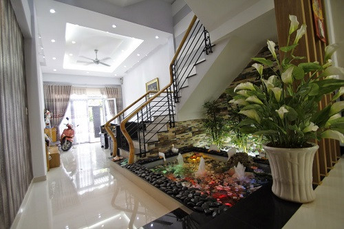 Bạn có thể bố trí tiểu cảnh với bể cá, hòn non bộ có suối chảy ở gầm cầu thang. Tuy nhiên, với kiểu tiểu cảnh này, bạn nên thiết kế cầu thang ngay cạnh giếng trời để khu vực gầm cầu thang được sáng sủa, không bị ẩm thấp. Ảnh: Khonggianxanh.