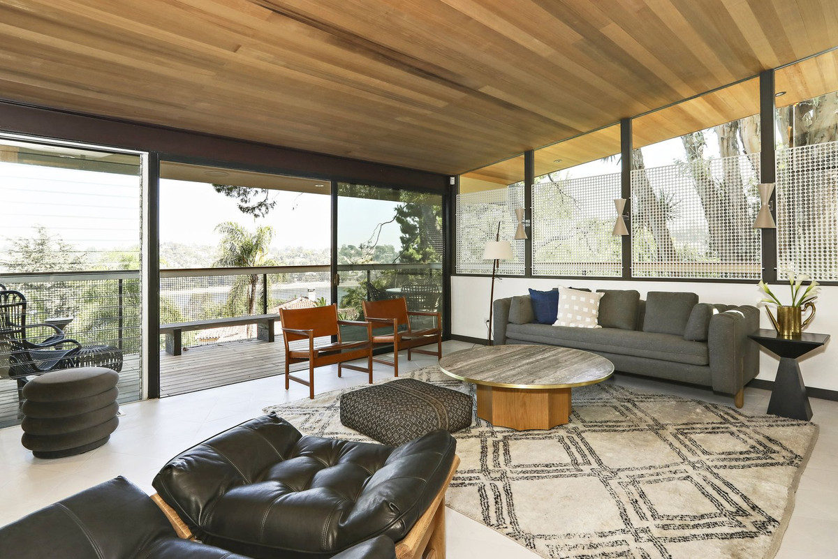 Trong phòng khách, trần nhà được ốp gỗ trong khi những bức tường được làm hoàn toàn bằng kính.