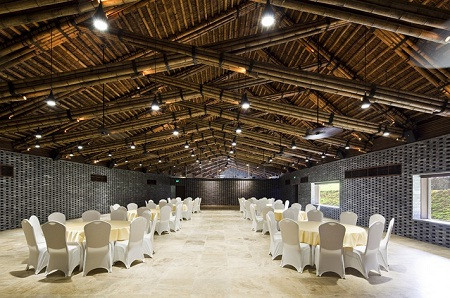 Dường như KTS Võ Trọng Nghĩa yêu thích thiết kế với những sản phẩm từ thiên nhiên như tre, đá, gỗ và nhà hội nghị Đại Lải cũng vậy. Ấn tượng đầu tiên của công trình là đá, bức tường đá cao 8m dựng đứng, cắm trên ba gò đất cảnh quan phủ cỏ. Bước vào không gian bên trong là tiếng râm ran trực thoại của đá, tre luồng và cảnh quan.