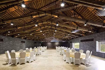 Dường như KTS Võ Trọng Nghĩa yêu thích thiết kế với những sản phẩm từ thiên nhiên như tre, đá, gỗ và nhà hội nghị Đại Lải cũng vậy. Ấn tượng đầu tiên của công trình là đá, bức tường đá cao 8m dựng đứng, cắm trên ba gò đất cảnh quan phủ cỏ. Bước vào không gian bên trong là tiếng râm ran trực thoại của đá, tre luồng và cảnh quan.