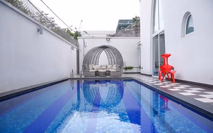 Bể bơi bên ngoài rất rộng, lát đá xanh nghệ thuật và có đặt bàn trà như không gian của những khách sạn. Ảnh: Ngoisao.