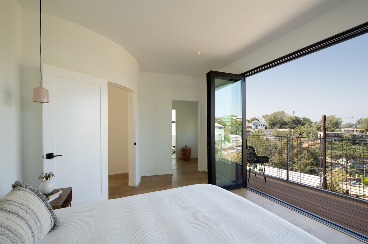 Phòng ngủ cực thoáng mát với cửa kính lớn và ban công nhỏ làm nơi thư giãn, ngắm cảnh.