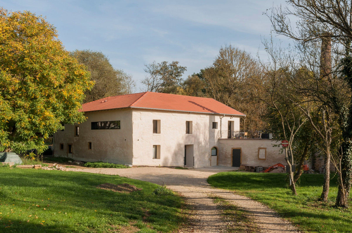 Ngôi nhà dường như nằm lọt thỏm giữa thiên nhiên với nhiều cây cối và thảm cỏ xanh.