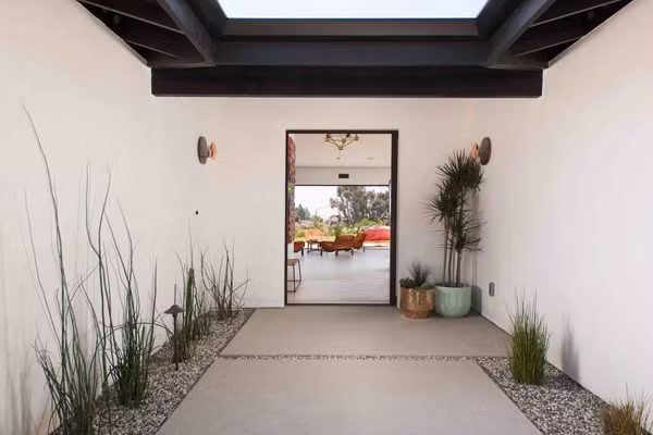 Lối vào nhà được trải đá hai bên và điểm thêm cây xanh. Ảnh: Homedsgn.