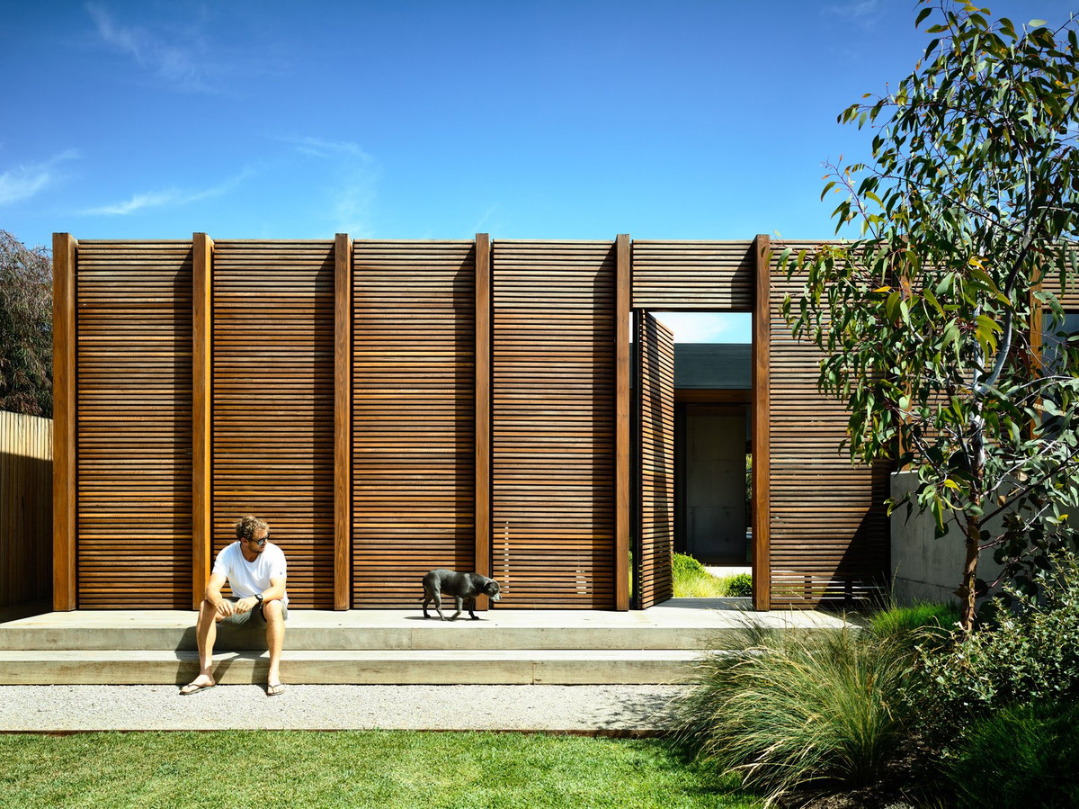 Tường bao quanh nhà được làm từ những thanh gỗ xếp song song vừa đảm bảo sự an toàn, riêng tư lại khiến ngôi nhà không bị cảm giác bí bách.