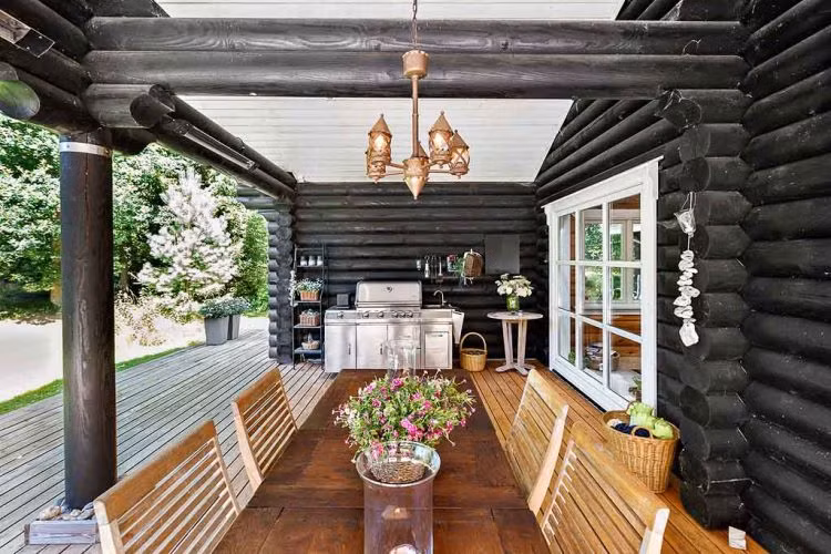 Ngôi nhà gỗ có nhiều cửa sổ và cửa ra vào với kích thước lớn, mang lại sự thông thoáng cho toàn bộ không gian.