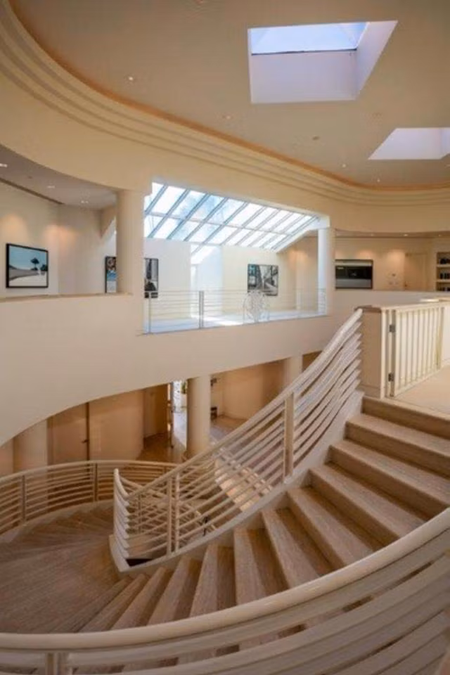 Biệt thự này có một cầu thang lớn và cả một bộ sưu tập tranh nghệ thuật được gắn trên tường dọc cầu thang.