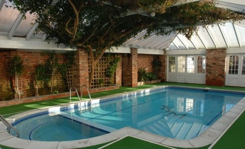 Dù ở trong nhà nhưng thiết kế bể bơi này mang đến cho ta cảm giác không khác gì như một bể bơi ngoài trời nhờ những lùm cây xanh mướt. Ảnh: Emaux.