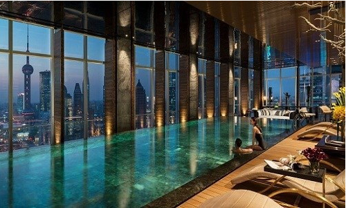 Đây là một mẫu thiết kế bể bơi trong nhà vô cùng tinh tế và sang trọng. Với vách kính trong suốt, bạn vừa có thể vừa thỏa sức bơi lội, vừa có thể ngắm nhìn khung cảnh thành phố lung linh tuyệt đẹp ngoài kia. Ảnh: Blogspot.