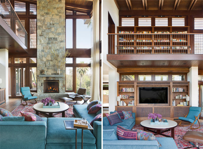 Phòng khách nổi bật với lò sưởi ốp đá và bộ ghế sofa màu xanh kết hợp thảm trải sàn có hoạt tiết và màu sắc bắt mắt.