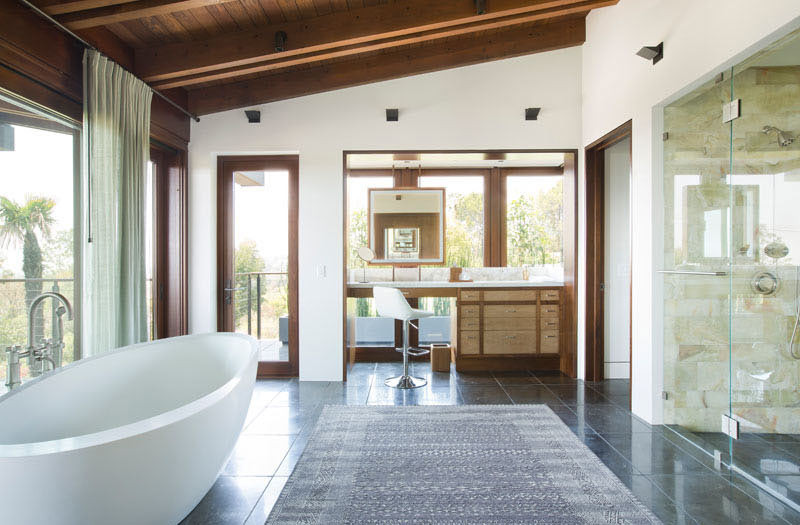 Phòng tắm cực kỳ sang trọng và rộng rãi với hai kiểu bồn tắm: một bồn tắm màu trắng nằm cạnh cửa sổ trong khi bồn tắm đứng có vách ngăn bằng cửa kính.