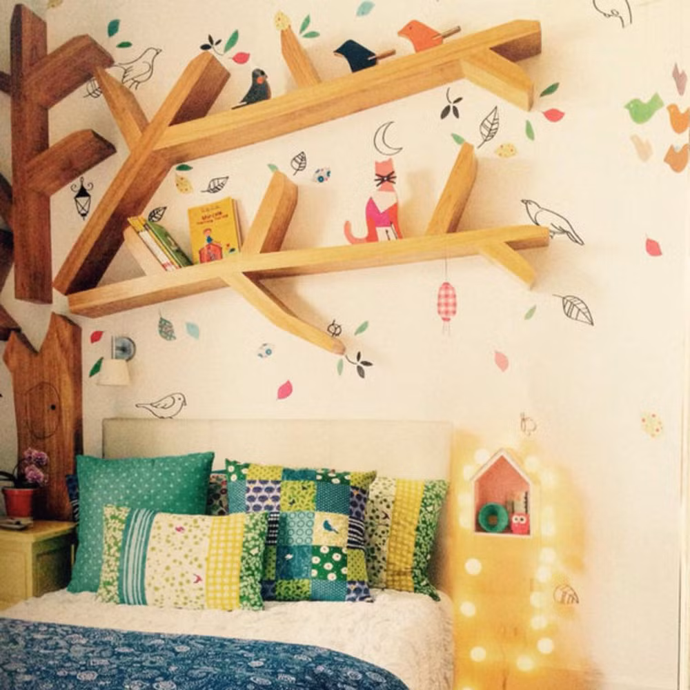 Giá sách hình cành cây. Giá sách này có vẻ kỳ công để đóng nhưng sẽ làm cho căn phòng trở nên khác biệt và phong cách hơn. Giấy dán tường có họa tiết thiên nhiên lại càng phù hợp với giá sách hơn.