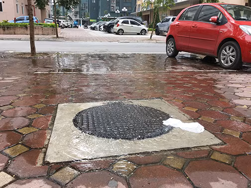 Nước bể phốt từ hố ga tràn cả ra đường, gây ô nhiễm môi trường. Ảnh: Việt nam mới.