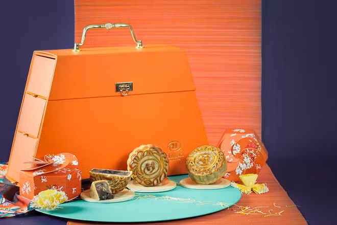 Bánh Trung thu Hilton 2018 mới ra mắt trên thị trường nhưng đã được nhiều gia đình tại Hà Nội lùng mua để làm quà biếu nhân dịp Tết Trung thu sắp tới bởi hộp bánh này có vẻ ngoài khá độc, lạ giống như chiếc túi xách nhỏ màu cam với móc khóa và tay cầm tỉ mỉ.