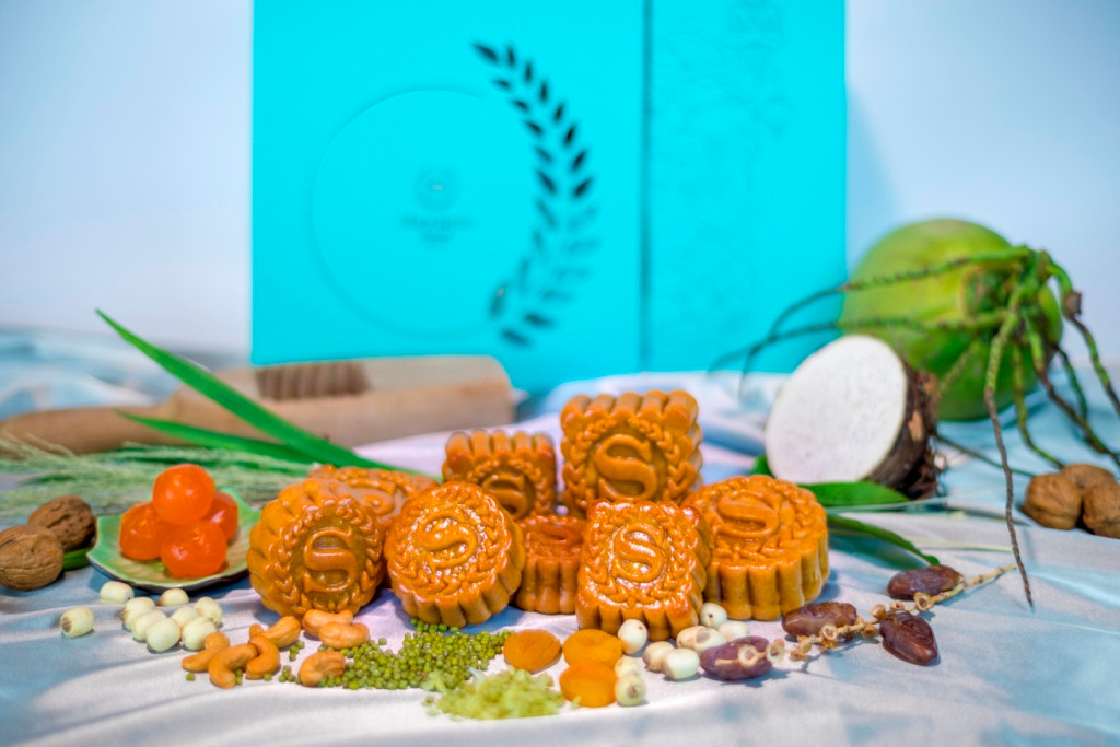 Bánh của thương hiệu này gồm các loại nhân: Cốm và dừa non, đậu xanh hạt điều trứng muối, trà xanh mơ khô, khoai môn chà là...